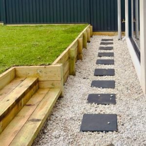side of house landscaping ideas paving, pebbles and timber retaining wall